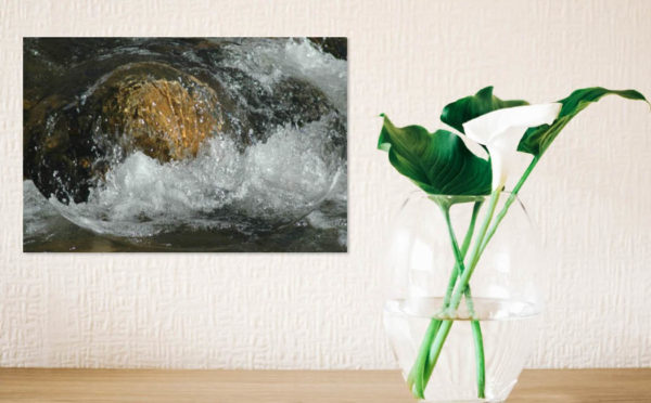 Cycle photo of water flowing over a rock in a room